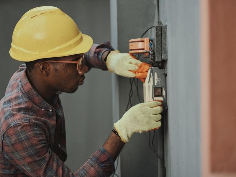 Electrician testing an electrical panel with a multimeter in Ottawa