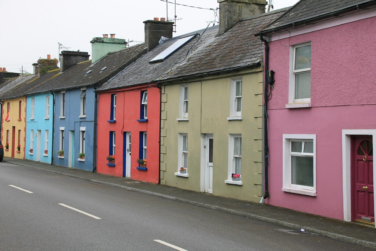 A row of brightly coloured terraced houses along a street