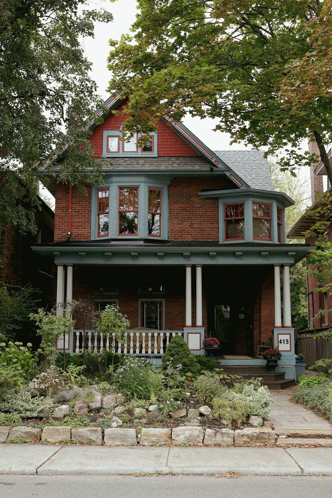 A red brick Canadian house with a large covered front porch