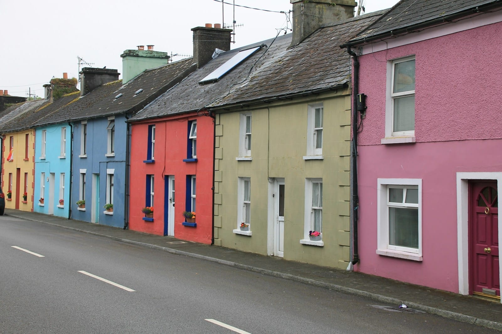 A row of brightly coloured terraced houses along a street