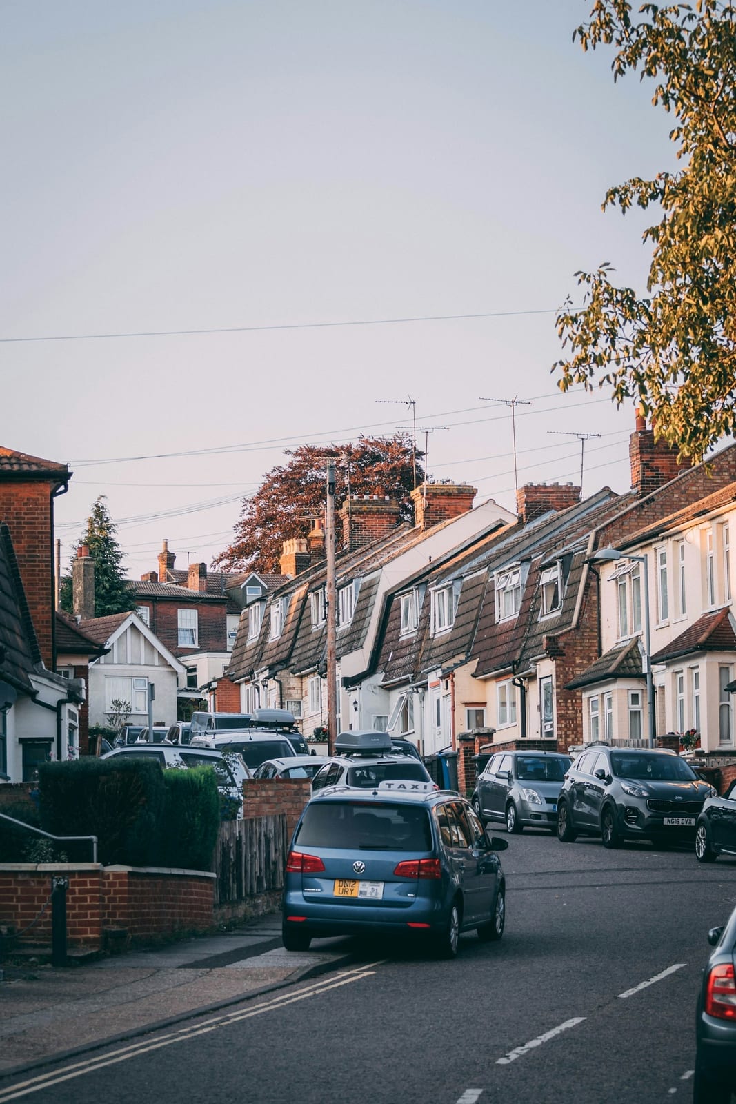 Cars parked in front of white and brown terraced houses on a British street
